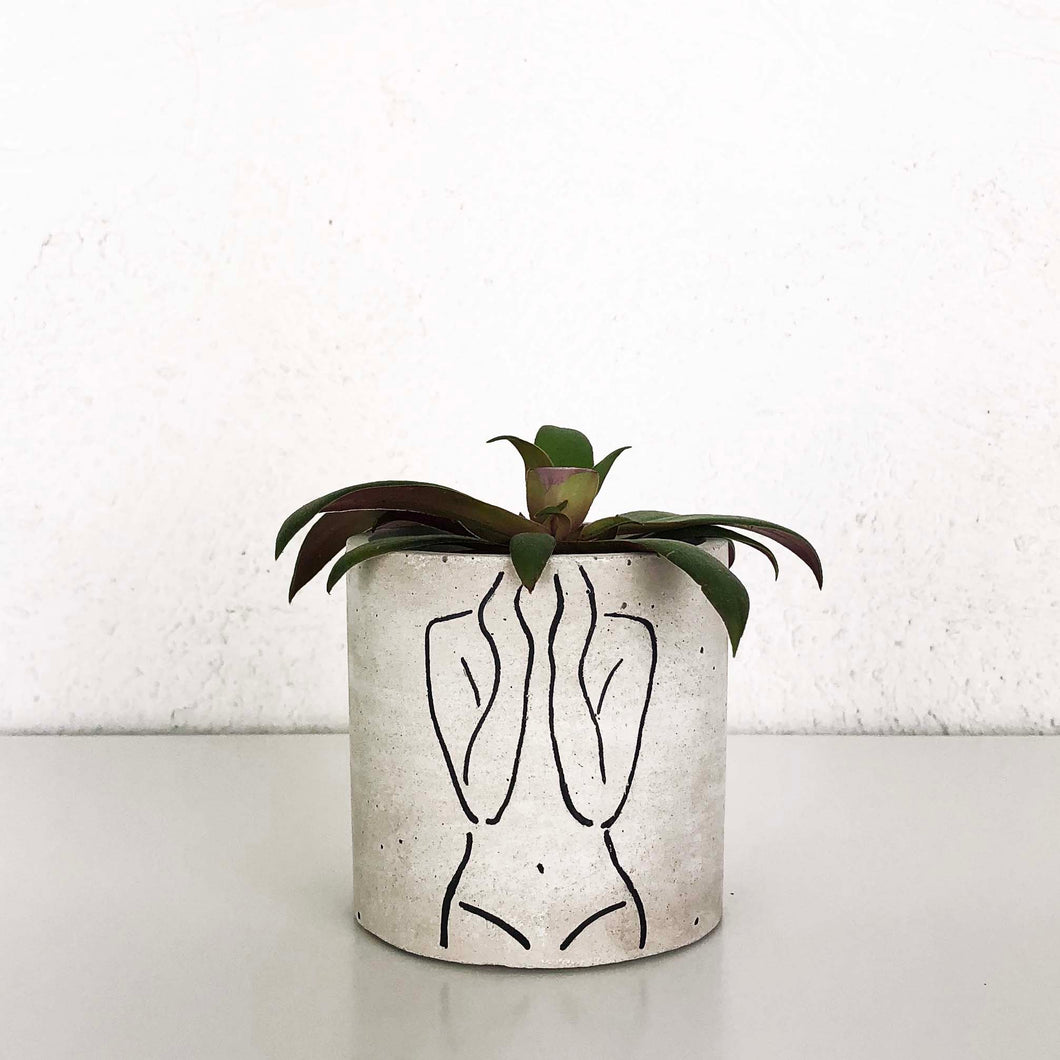 small concrete planter with female torso artwork
