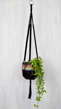Black hand painted retro plant pot hanging from a black plant hanger
