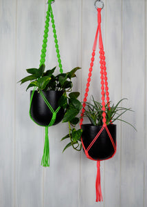 Two neon coloured plant hangers with black hand painted planters