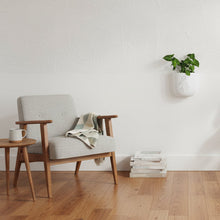 Modern living room with a beige armchair, and wooden floor.