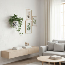 Modern living room with a light wood console table, gray sofa, and decorative elements.