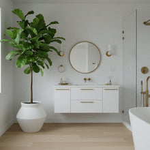 Modern bathroom with white vanity, freestanding bathtub, and potted plant.