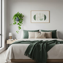 Neatly made bed with green and beige bedding in a bedroom setting.