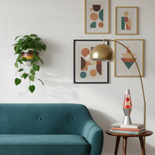 Modern living room with teal sofa, abstract art, and decorative lamp.