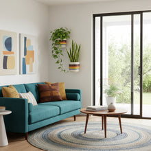 Modern living room with teal sofa, round rug, and large window