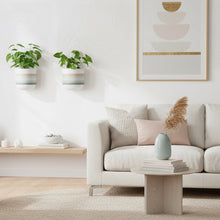 Modern living room with a white sofa, hanging plants, and other decorative elements.