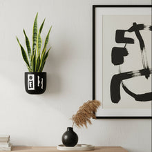 Modern living room with wooden TV stand, abstract art, and a plant.