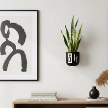 Modern living room with wooden TV stand, abstract art, and a plant.