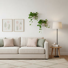 Living room with a beige sofa, side table, lamp, and wall art.
