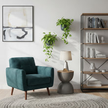 Modern living room with teal armchair, side table, and bookshelf.