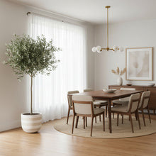 Modern dining room with wooden table, chairs, and decorative elements.