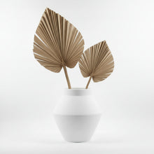 White vase with dried palm leaves on a light gray background