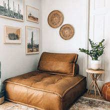 Brown leather sofa in a room with wall art and decor