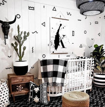 black and white bedroom with crib, plants and wall decals