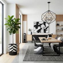 Modern dining room with a geometric chandelier, abstract art, and a fiddle leaf fig tree plant.