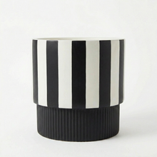 Black and white striped pedestal plant pot on a white background