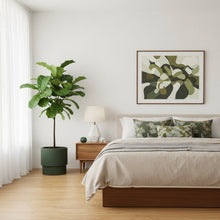 Modern bedroom with a bed, plant, and artwork on the wall.