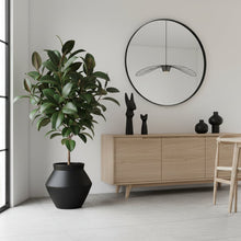 Modern dining room with wooden furniture, plants, and a mirror on the wall.