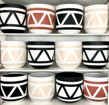triangle motif bohemian inspired planters on a white shelf