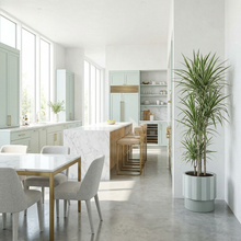 Modern kitchen with marble countertops, stainless steel appliances, and a large window.