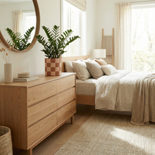 Japandi-inspired bedroom with wooden dresser, bed, and decorative elements.