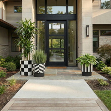 Stylish house entrance with black door and decorative planters.