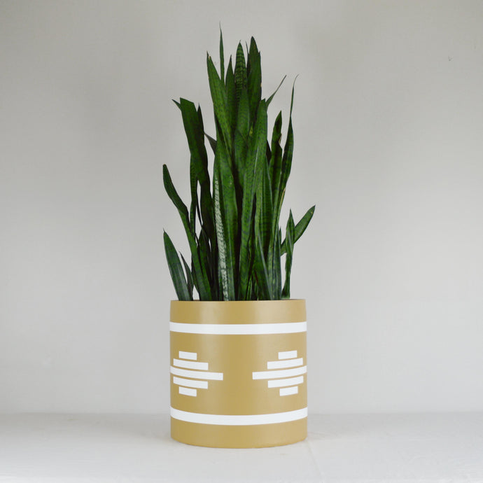 A yellow hand-painted planter with geometric pattern by Common House Studio.