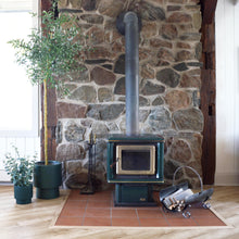 Stone mantle with a green free standing fireplace stove.  Matching green planters placed on floor to left side of the mantle.