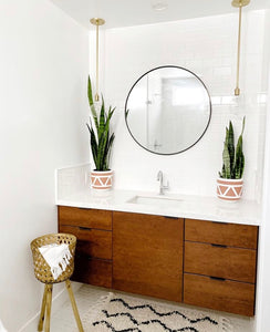 two terracotta aztec bohemian planters on counter top in powder room 