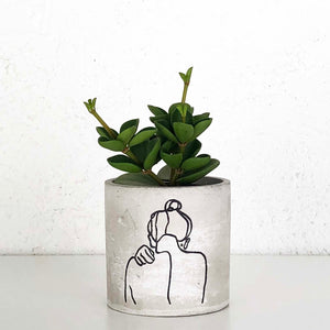 concrete planter with outline of the back of a lady with her hair in a bun
