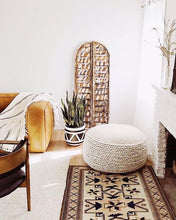 aztec design planter in living room with large pouf