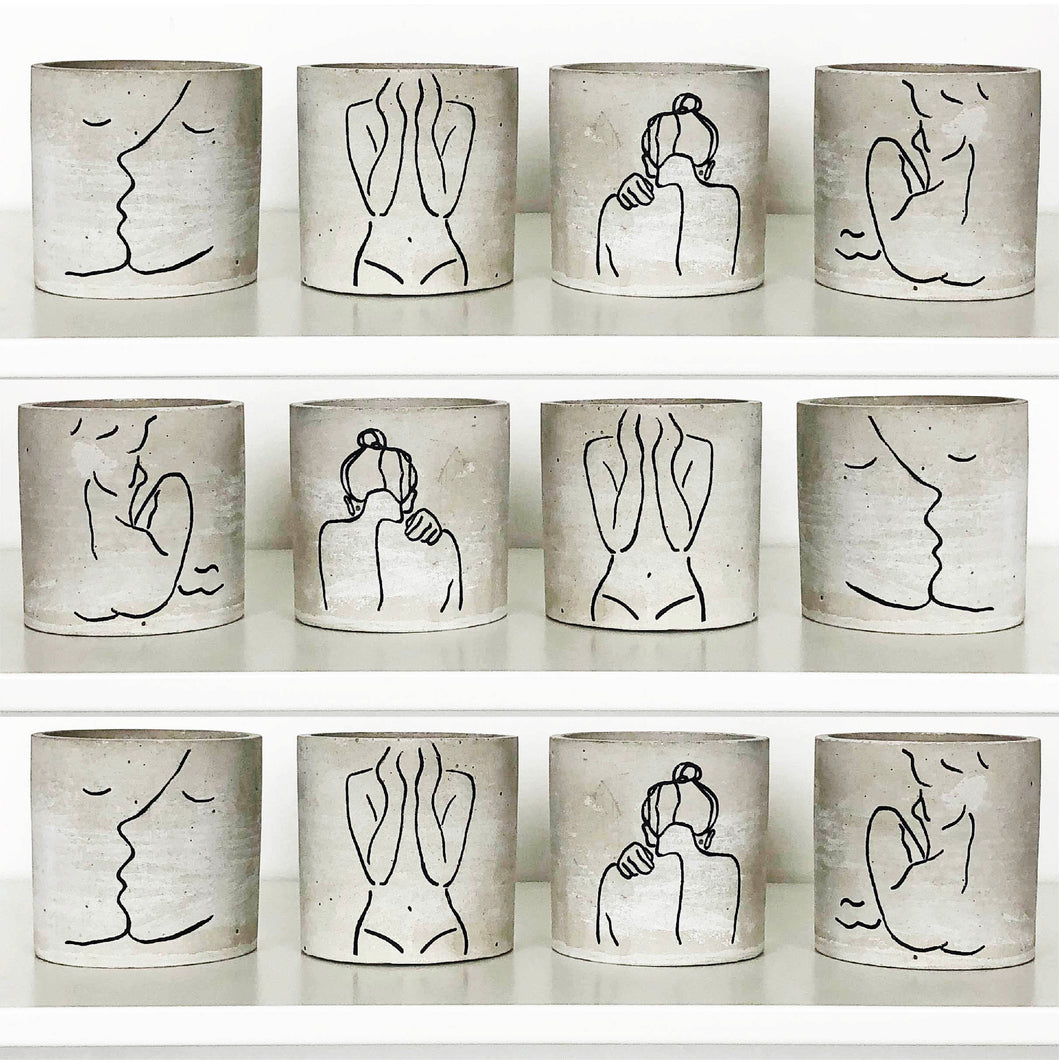 Twelve mini Forgotten Property concrete planters on a white shelf