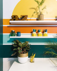 white and gold planter pot placed on desk in retro themed bedroom