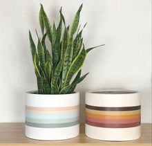 set of mid century modern designed with retro stripes on low cylinder planter pots