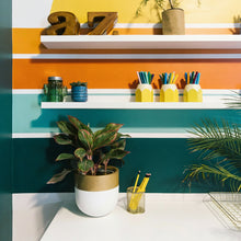 white and gold planter pot placed on desk in retro themed bedroom